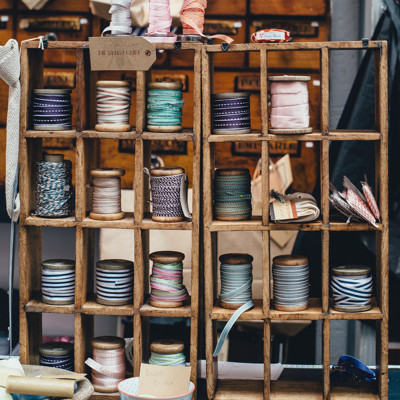 spools of thread and yarn on a wooden shelf